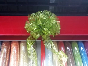 Large green glitter mesh Christmas bow with sparkling dot texture for holiday tree decor