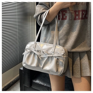 Dettaglio borsa a spalla grigio lucido con tasche a pieghe decorate da fiocchi eleganti
