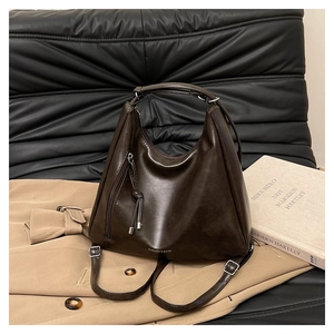 Detail of vintage brown large capacity leather backpack with fringe and triangle design