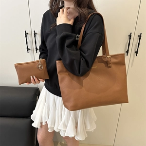 Large brown leather tote bag with FASHION logo and matching pouch worn by model
