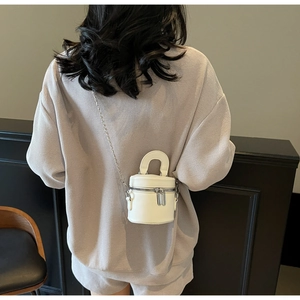 Detail-Rückansicht einer weißen Mini-Beuteltasche mit silberner Kette an einem Model