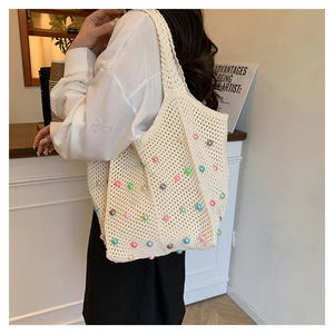 Detail of hand-woven beige tote bag with colorful pearls for a coastal vacation style