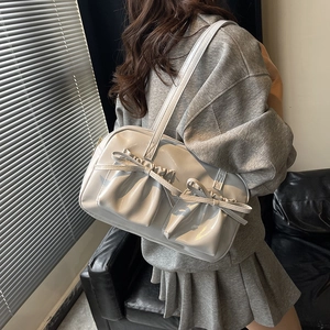 Elegante borsa a tracolla plissettata con fiocco in pelle verniciata argento su modella