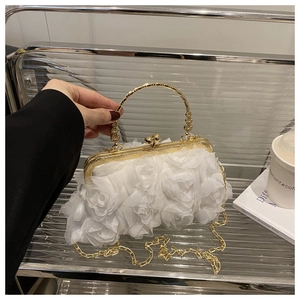 Close-up of white chiffon rose petal detail on evening bag with gold metal handle