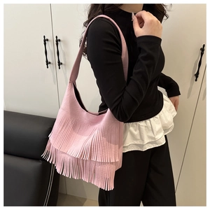 Dettaglio della borsa tote in pelle rosa con eleganti nappe lunghe a doppio strato
