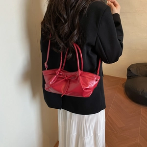 Elegant red dumpling bag with bow detail and adjustable strap for women fashion