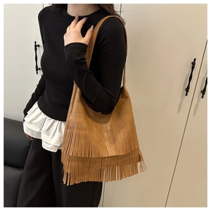 Dettaglio della borsa hobo in similpelle marrone con lunghe frange alla moda e tracolla