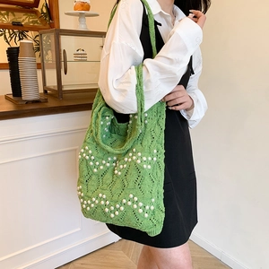 Sac cabas en tricot vert orné de perles blanches dans un cadre décontracté
