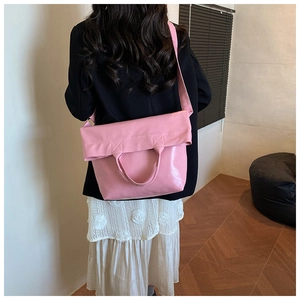 Vista trasera de una modelo con un bolso tote grande de cuero PU rosa y correa ancha