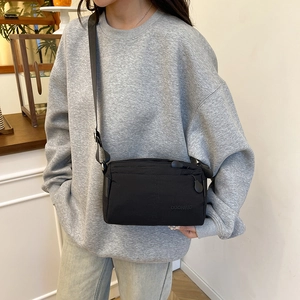 Minimalist black nylon crossbody bag for women with multi-layer zipper compartments