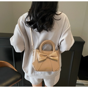 Detail of apricot PU leather square bag with large bow decoration and adjustable strap