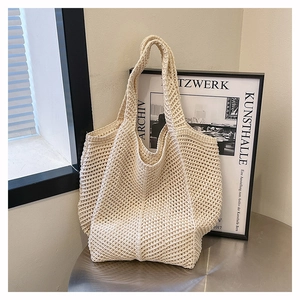 Détail d'un sac fourre-tout en maille beige sur table en métal et décor artistique