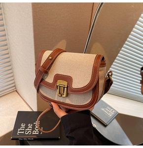 Detail of vintage canvas saddle bag with brown leather trim and contrast stitching