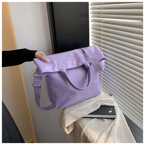 Detalle del bolso tote de piel sintética violeta mostrando grano fino y asas redondas