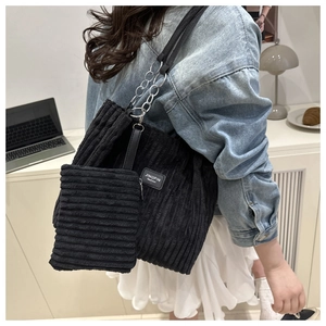 Detail of black corduroy tote bag with small matching pouch and silver chain strap