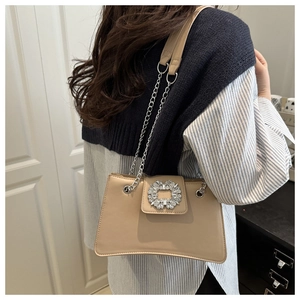 Détail du sac beige avec boucle carrée en strass scintillants et bandoulière en chaîne