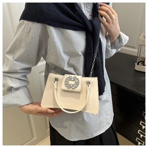 Détail du sac beige élégant avec boucle carrée en cristal et bandoulière en chaîne