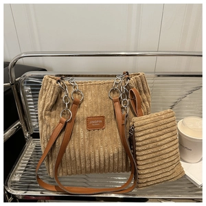 Detail of khaki corduroy tote bag with brown leather strap and matching small zipper pouch