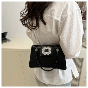 Détail de la boucle carrée argentée avec cristaux sur un sac à bandoulière noir