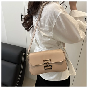 Detail of nude rectangular shoulder bag with golden interlocking clasp and smooth leather texture