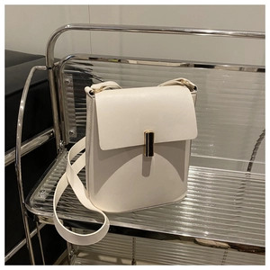 Détail du sac bandoulière en cuir blanc avec boucle de verrouillage en métal doré