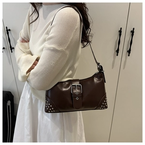 Détail d'un sac à bandoulière en similicuir marron avec boucle argentée et rivets