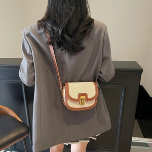 Chic saddle crossbody bag with beige canvas and brown leather trim for women