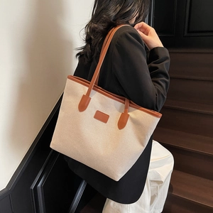 Minimalist off-white canvas tote bag with brown leather trim and large capacity