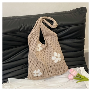 Detailed knit texture and delicate white floral embroidery on beige tote bag