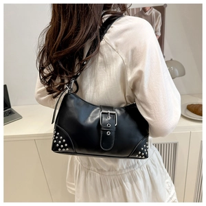Détail du sac hobo en cuir noir avec clous argentés et boucle décorative