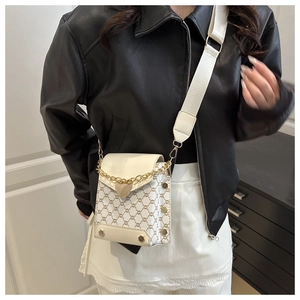 Vue détaillée du sac blanc avec motif chaîne, pendentif cœur et rivets dorés brillants
