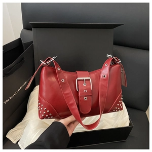 Détail du sac lune en cuir PU rouge avec clous argentés et fermeture à boucle large
