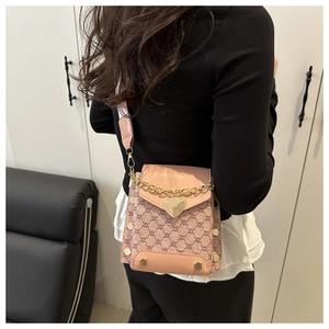 Vue détaillée du sac bandoulière rose à monogramme avec fermoir cœur porté par un mannequin