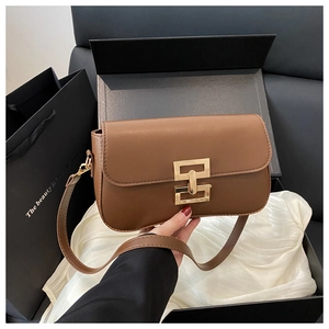 Detailed close-up of brown leather bag with gold buckle in premium gift box packaging