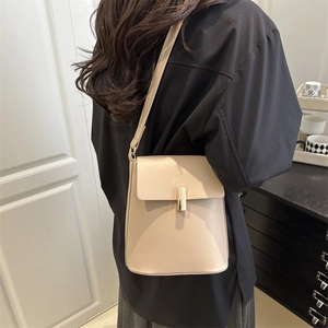 Sac seau en cuir mat beige avec une boucle en métal doré minimaliste et élégante