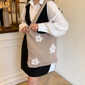 Chic beige knit tote bag with white floral cutout pattern for shoulder carry