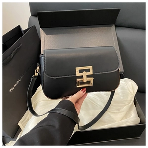 Detail of black matte square bag with gold geometric buckle in premium gift box
