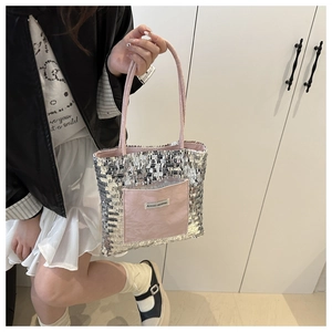 Detail of silver sequined tote bag featuring a pink pocket and slim shoulder straps