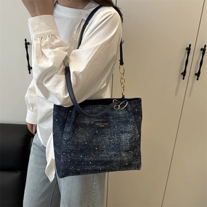 Blue denim tote bag with polka dot print, leather straps and gold chain detail