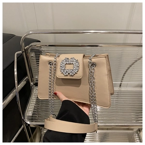 Détail du sac bandoulière en cuir beige avec une boucle argentée ornée de cristaux