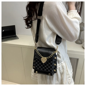 Détail du sac bandoulière avec motif vintage, pendentif coeur et sangle réglable