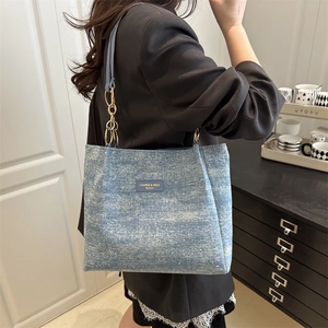 Blue denim-style tote bag with sparkling sequins and modern gold chain strap