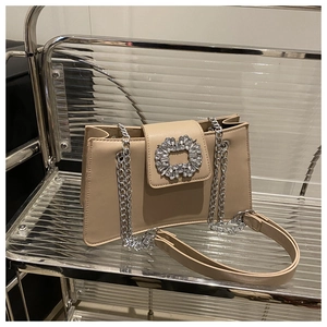Détail du sac en cuir beige avec boucle de strass carrée de luxe et bandoulière en chaîne