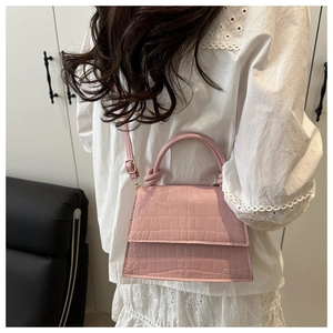 Pink faux croc leather square bag shown crossbody on a model for scale and style