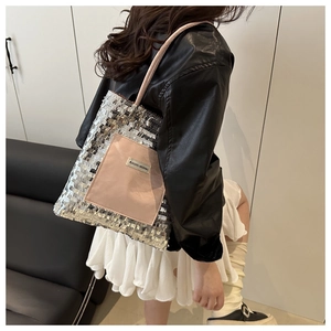 Detail of silver sequin tote bag featuring a pink contrast pocket and slender straps