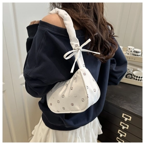Détail du sac croissant en coton blanc avec motifs animaux et nœud décoratif