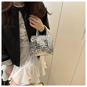 Close-up of a silver sequin tote bag showing sparkling texture and metal chain strap