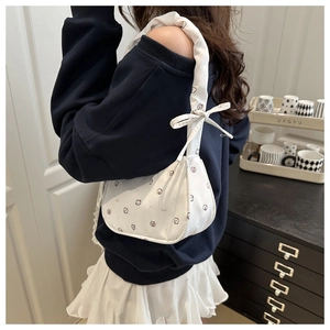 Détail du sac croissant en toile blanche avec imprimés chats mignons et nœud décoratif