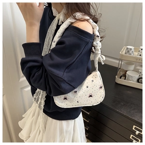Détail du sac croissant blanc avec imprimé ours coloré et bandoulière plissée