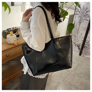 Chic black high-gloss leather tote bag with long shoulder straps for elegant office wear